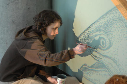 A student helping to projection paint salmon 